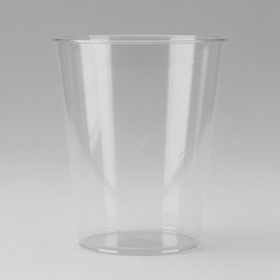 Close-up of a perfectly formed clear plastic cup with a few subtle imperfections, indicating minor manufacturing defects, on a clean, light background